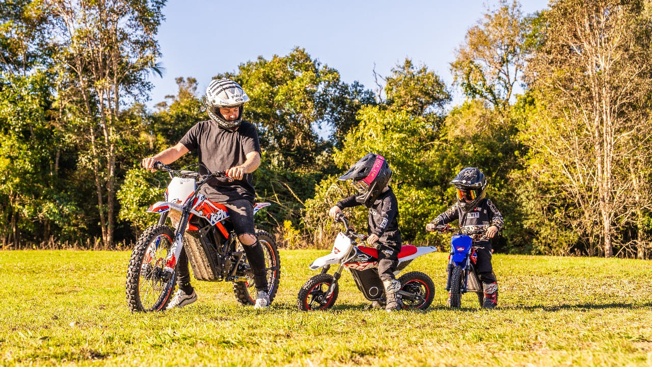 parent teaching kids riding dirt bikes